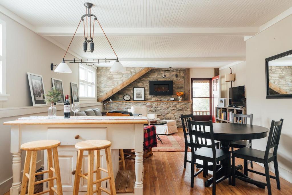 uma cozinha e sala de estar com mesa e cadeiras em Hummingbird House by Country House Escapes em Pine Hill