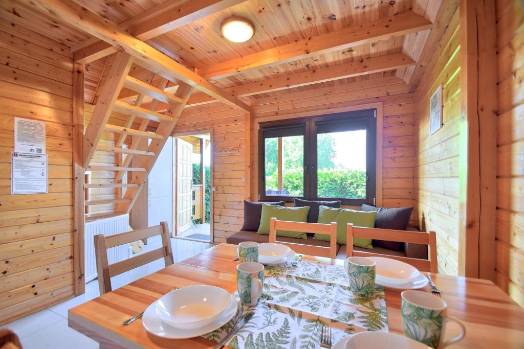 a wooden dining room with a table and chairs at Houses with a garden- Domki z ogródkiem Radison domki in Mielno