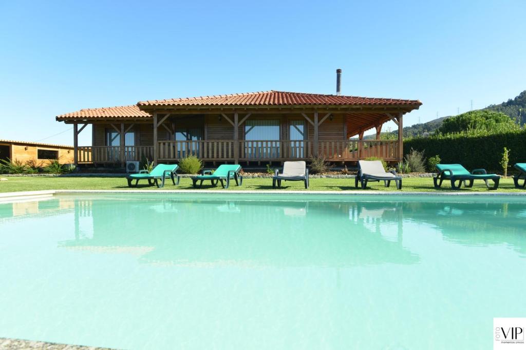 a large swimming pool with a house in the background at Casa da Moda - Turismo de Campo in Vieira do Minho