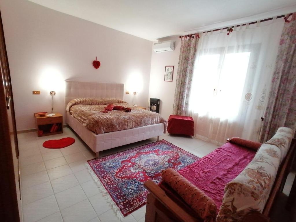 格羅塔列的住宿－B&B Lo Smeraldo，一间卧室配有一张床、一张沙发和一个窗口