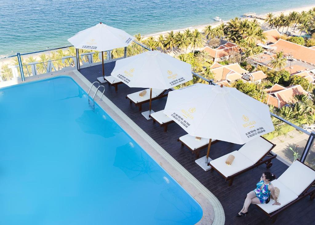 eine Aussicht über den Pool des Resorts mit Sonnenschirmen in der Unterkunft Regalia Nha Trang in Nha Trang