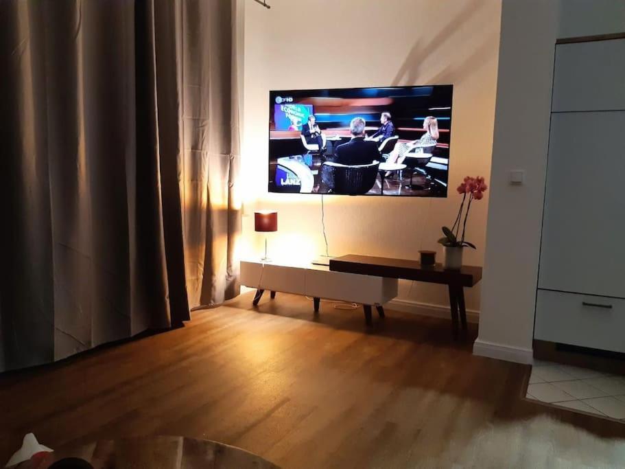 a living room with a flat screen tv on the wall at Helle, offene Whg im Zentrum vom Ostseebad Göhren in Göhren