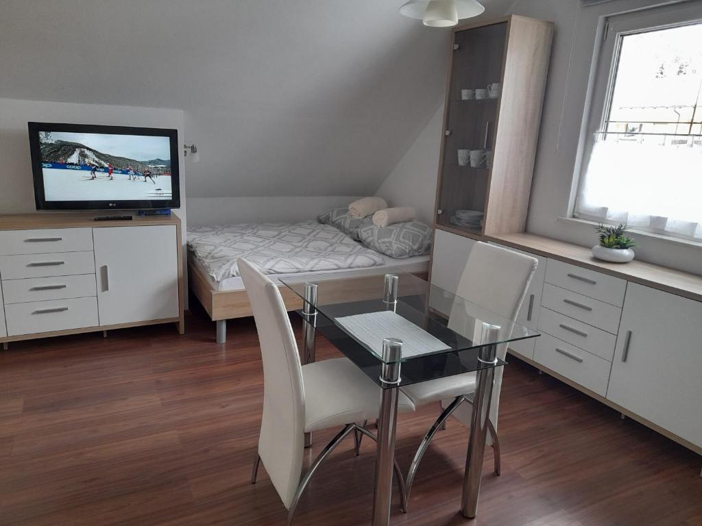 Cette petite chambre comprend une table à manger et un lit. dans l'établissement Apartma Lena, à Kranjska Gora