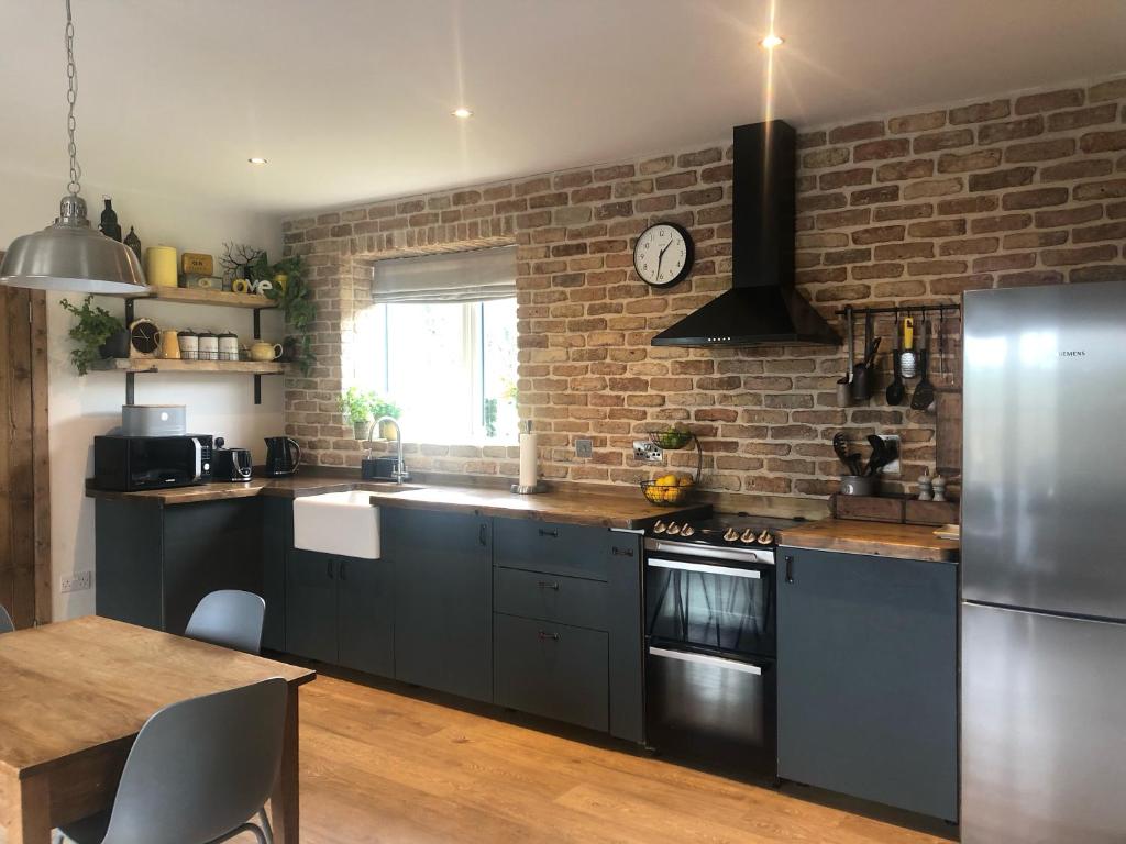 a kitchen with black appliances and a brick wall at Sandyhill Guest House - Westport in Westport