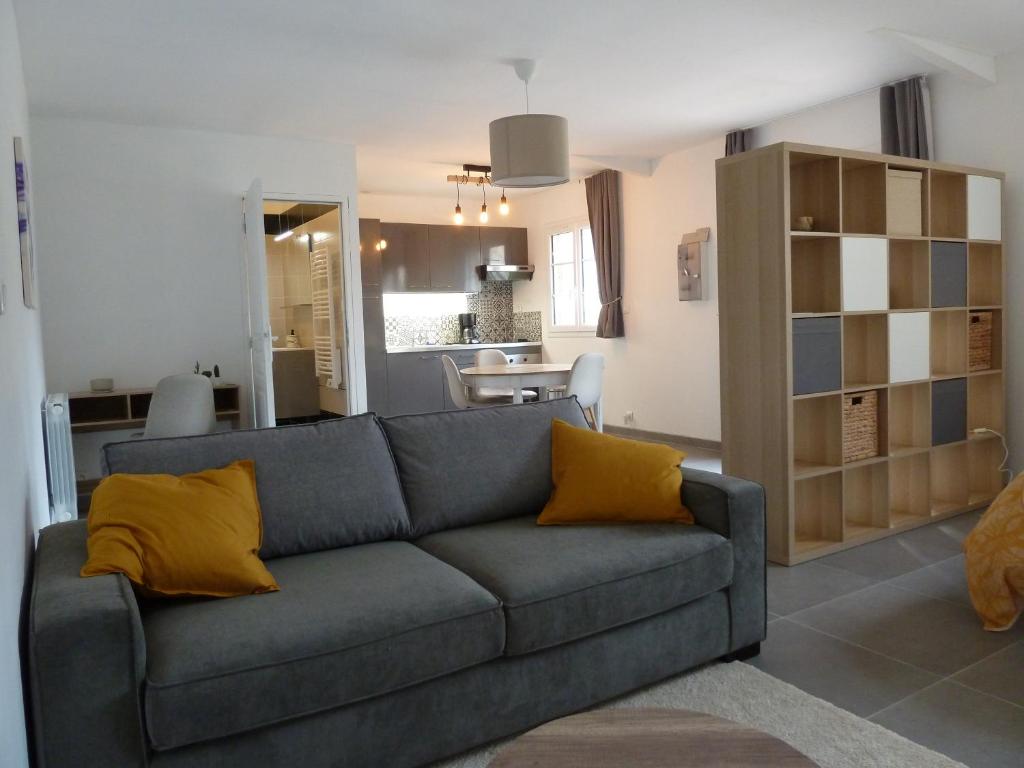 a living room with a gray couch and yellow pillows at Gite à Grez 