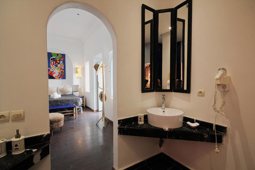 uma casa de banho com um lavatório e um espelho em Riad Pierres et Saveurs Soleil em Marrakech