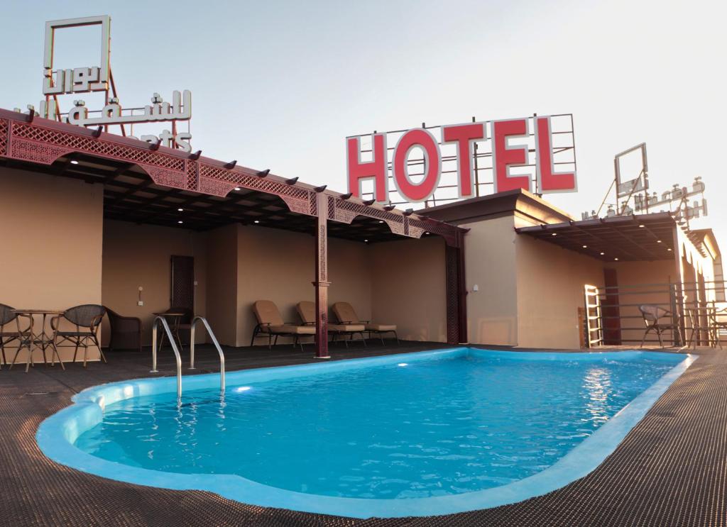 a hotel with a swimming pool in front of a hotel at Ewann Hotel Apartments in Nizwa