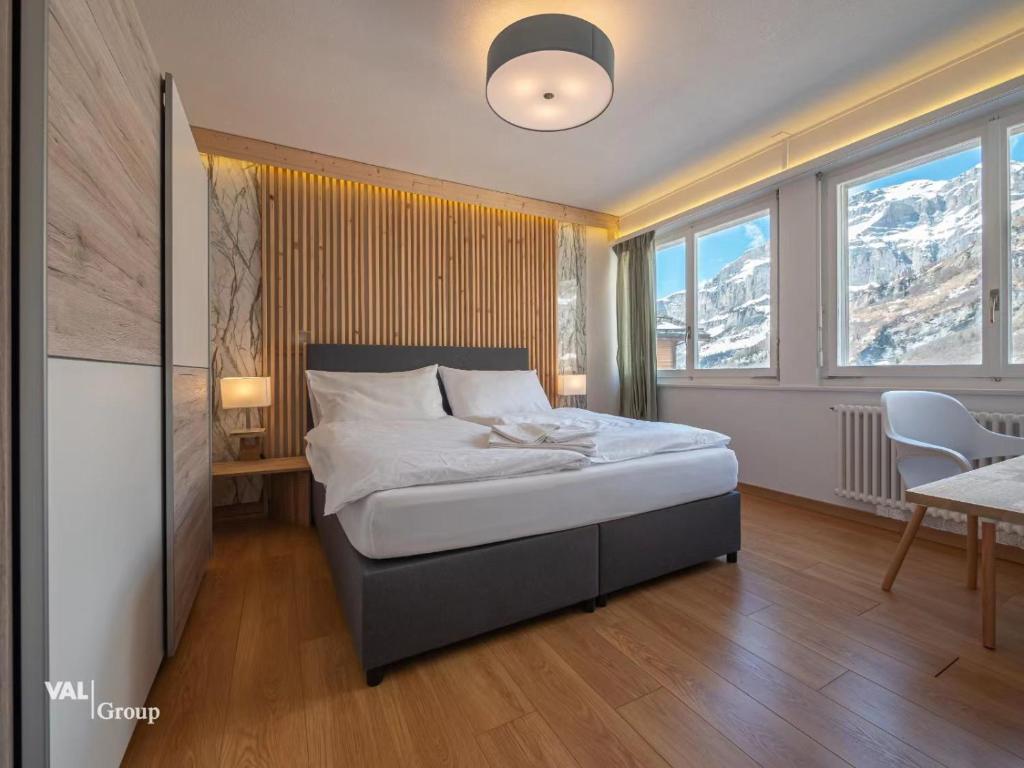a bedroom with a bed and a table and chairs at Center, Sauna - Haus LINARIA in Leukerbad