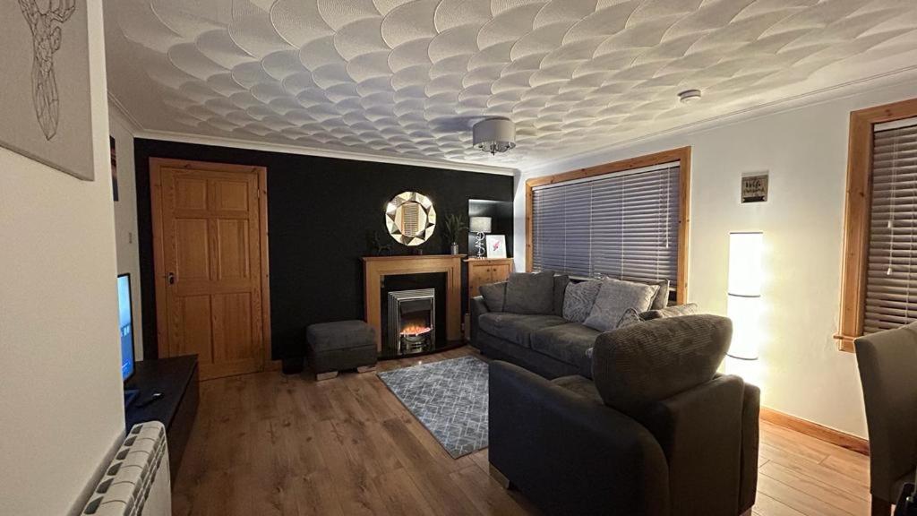 uma sala de estar com um sofá e uma lareira em 36 Westview Terrace em Stornoway