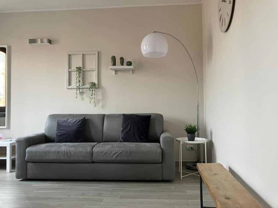 a living room with a gray couch and a table at Casa Patrito - appartamento Nebbiolo in Barolo