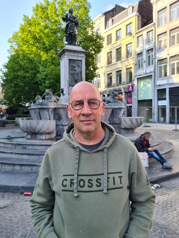 Um homem está de pé em frente a uma fonte. em Haus Päsch nahe See mit beheiztem Whirlpool/Sauna em Bütgenbach