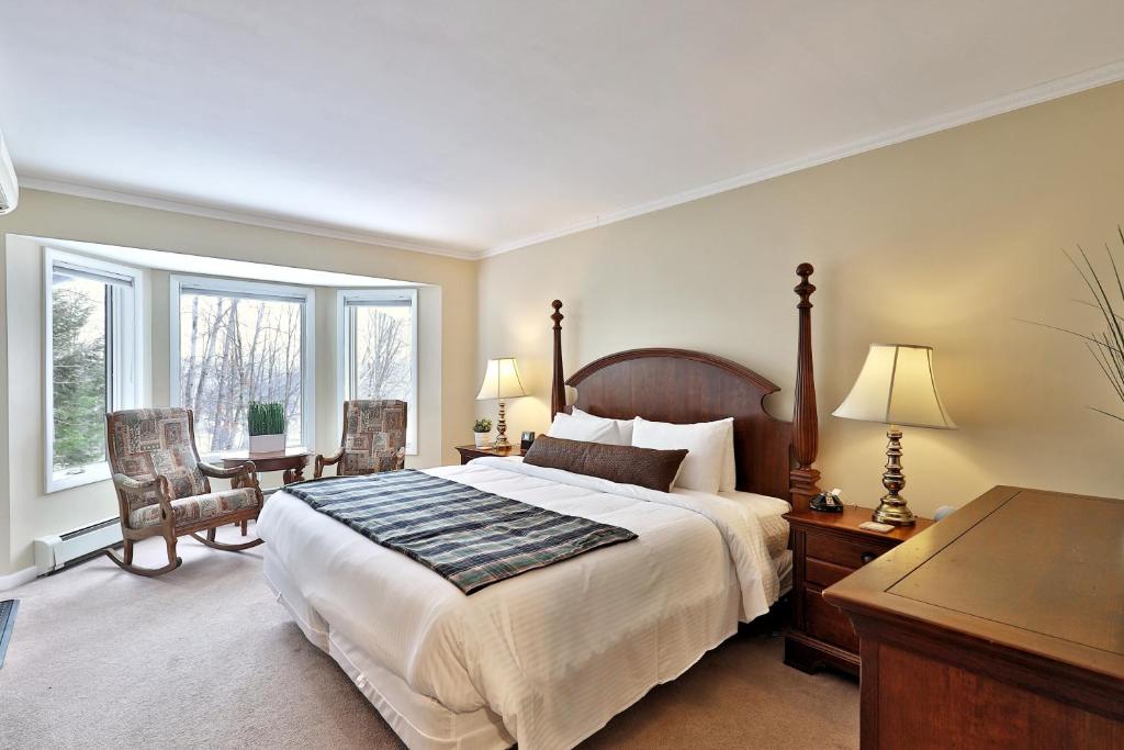 een slaapkamer met een groot bed en een tafel en stoelen bij The Birch Ridge- English Gentleman's Room #9 - King Suite in Killington, Vermont, Hot Tub, home in Killington