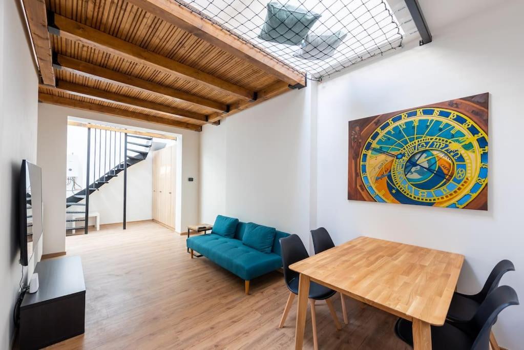 布拉格的住宿－Astronomical Clock Apartment，客厅配有蓝色的沙发和桌子