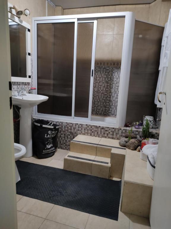 a bathroom with stairs and a sink and a toilet at Casa Isa in Ezeiza