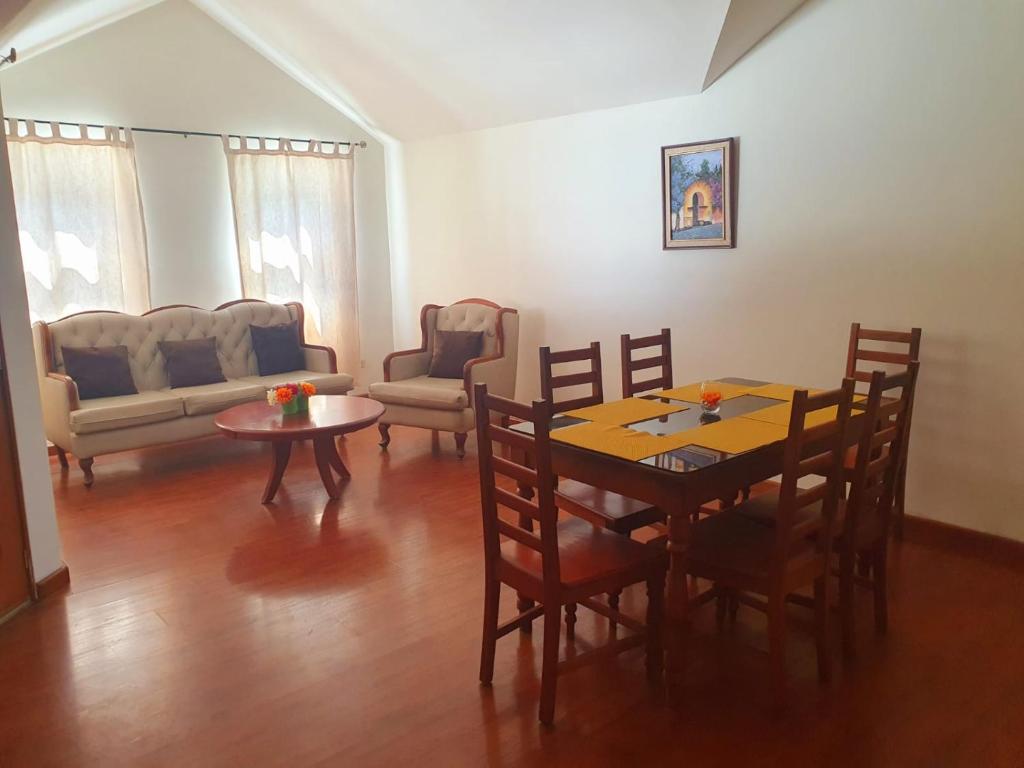 - un salon avec une table, des chaises et un canapé dans l'établissement Apartamento Aeropuerto La Aurora Guatemala, à Guatemala
