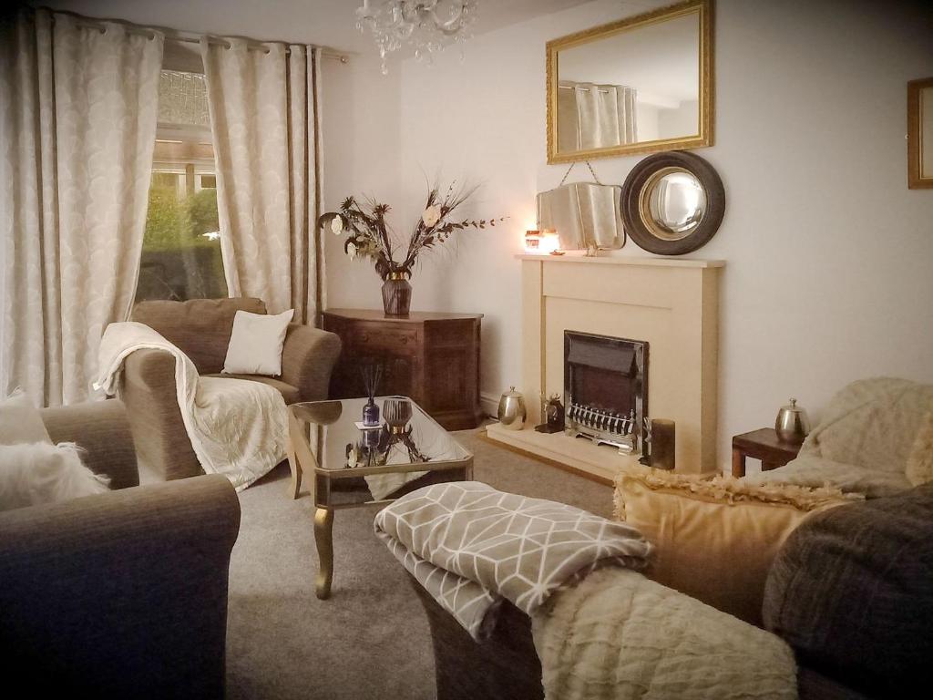 sala de estar con sofá y chimenea en The Saddlers Cottage en East Boldon