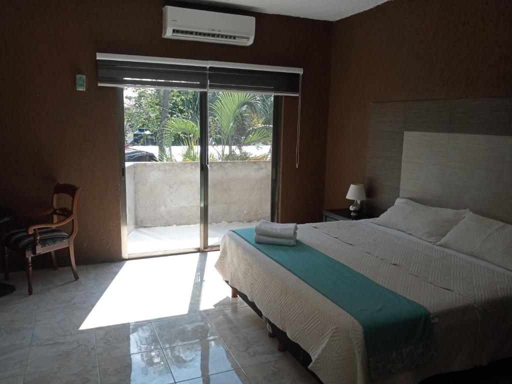 a bedroom with a bed and a sliding glass door at El Mirador Holbox in Holbox Island