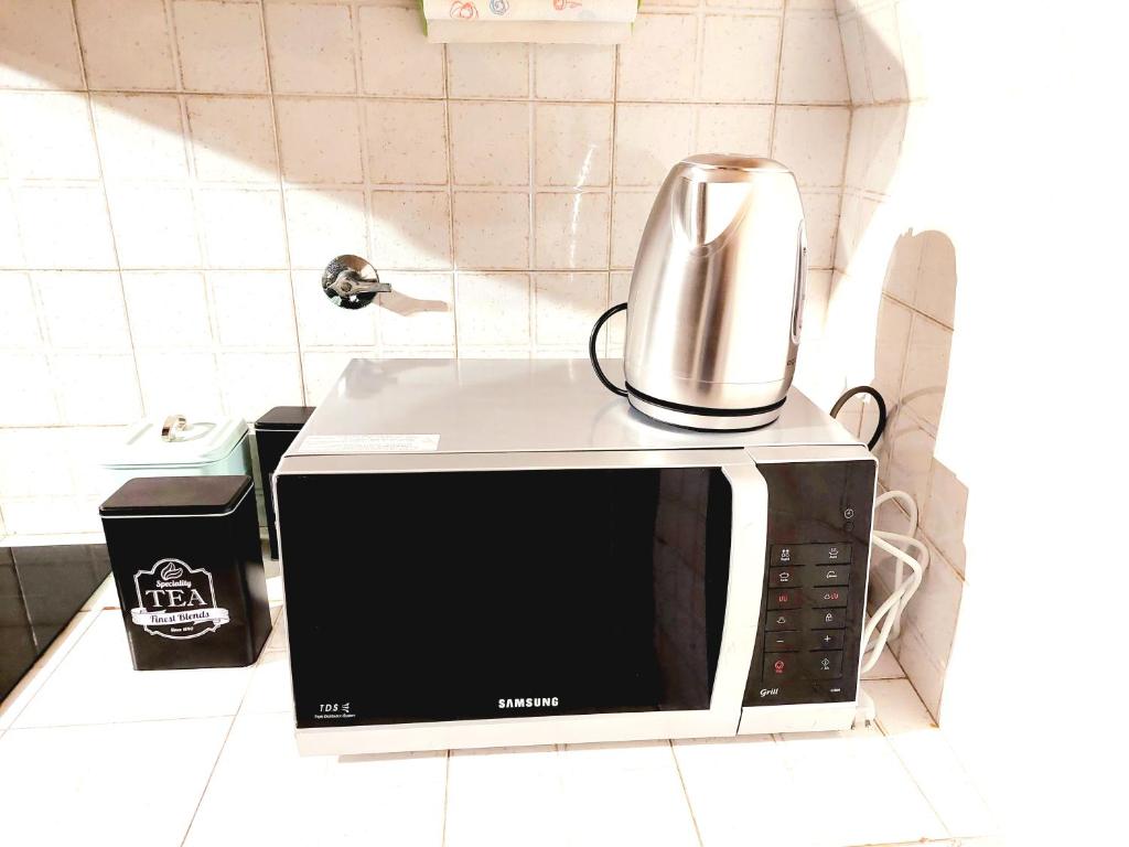 a microwave with a coffee pot on top of it at Trastevere in Music in Rome