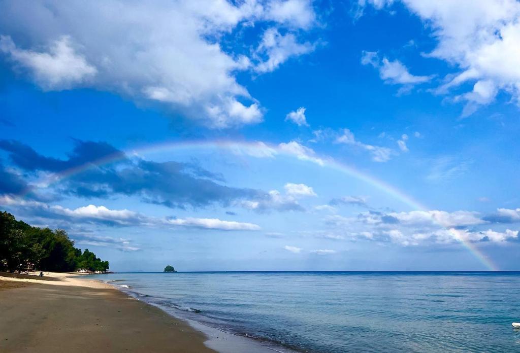 einen Regenbogen am Himmel über dem Strand in der Unterkunft Tioman Cabana Bed & Breakfast in Tioman Island