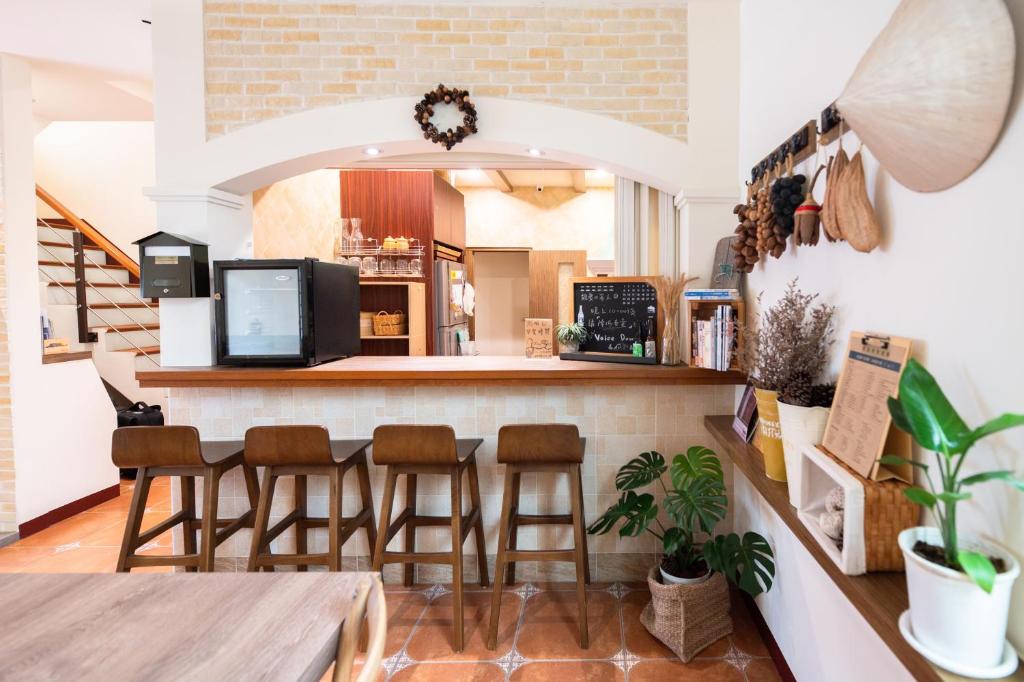 uma cozinha com um bar com bancos no balcão em THEDAY B&B em Magong