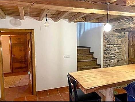 une salle à manger avec une table en bois et des escaliers dans l'établissement Casa brañas, 