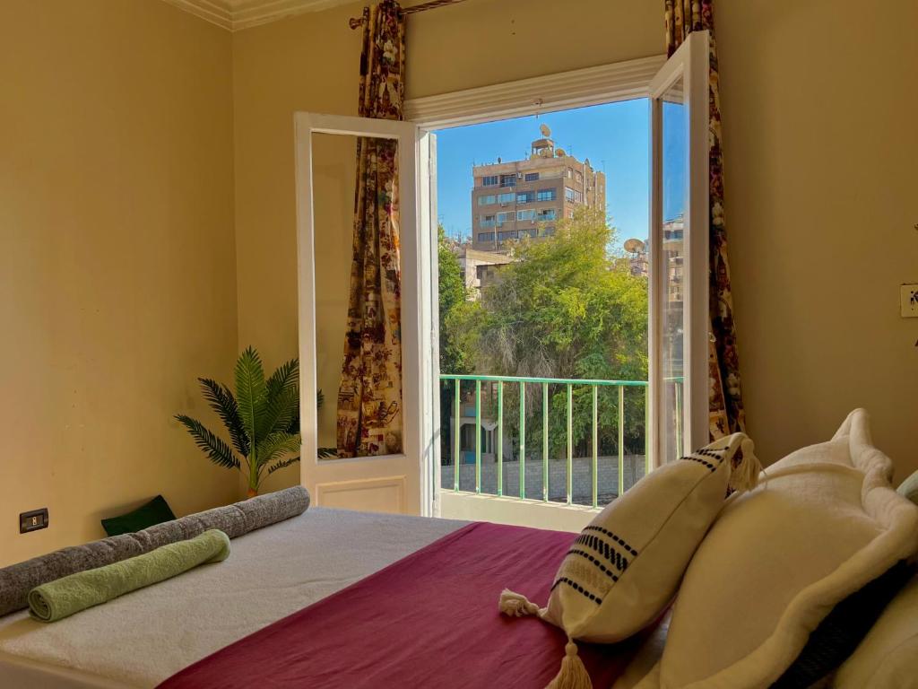 um quarto com uma cama e uma grande janela em شقة هادئة في الزمالك no Cairo