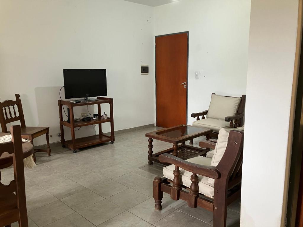 sala de estar con muebles de madera y TV en Departamento centro en La Rioja