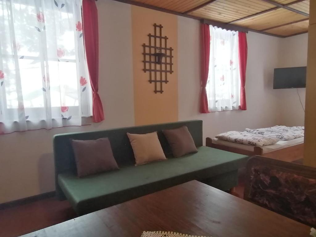 sala de estar con sofá verde y cama en Apartma, en Selnica ob Dravi