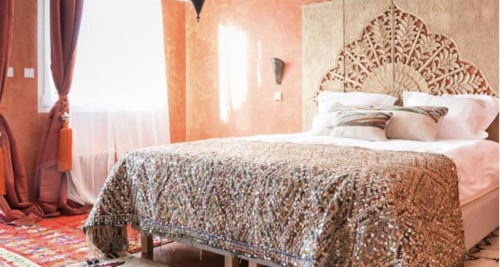 a bedroom with a bed with an ornate headboard at Riad SPA &quot;Les Portes de l&#39;Orient&quot; TOURS in Tours