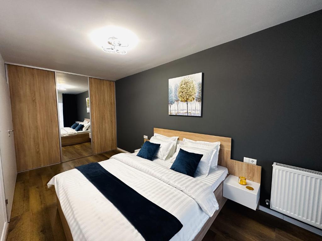 una camera da letto con un grande letto con cuscini blu di AD Apartments a Cluj-Napoca