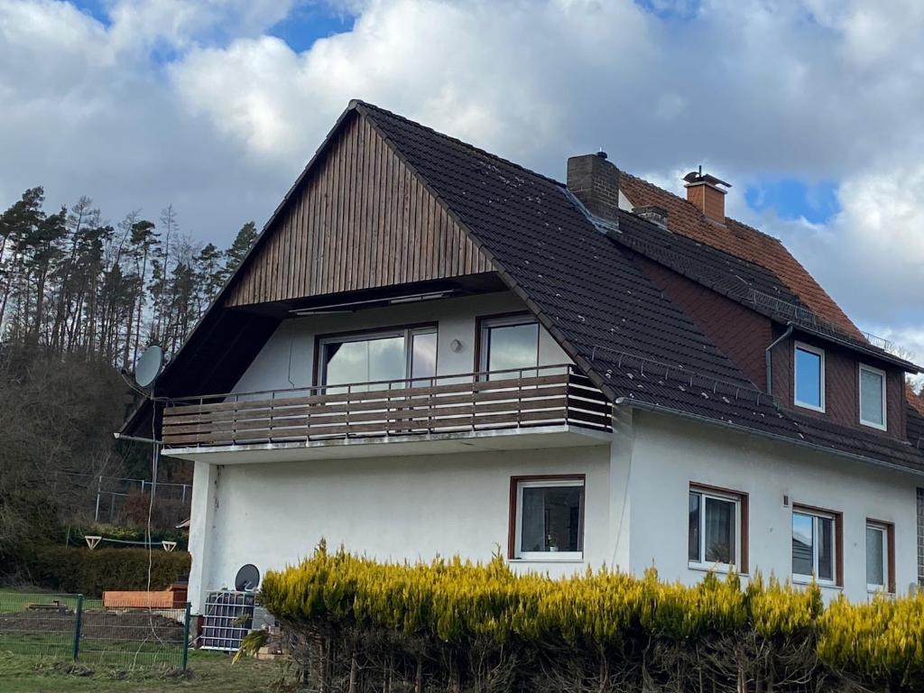 een wit huis met een bruin dak bij Kleine Elbequelle in Wolfhagen