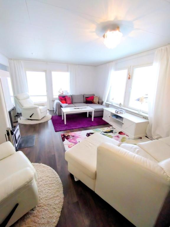a living room with white furniture and large windows at Ailo in Inari