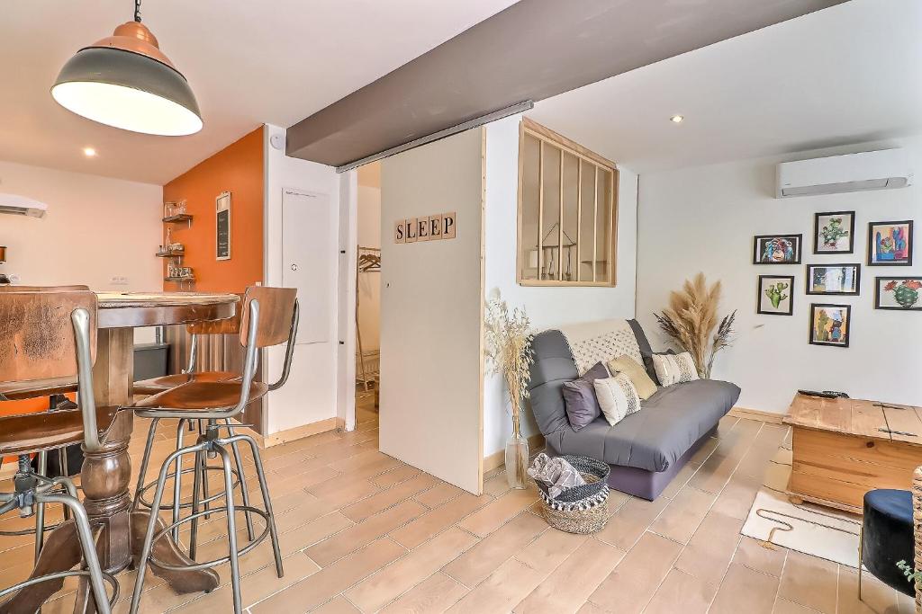 a living room with a couch and a table at Le carpe diem, appt à 10 min de Nîmes in Bouillargues