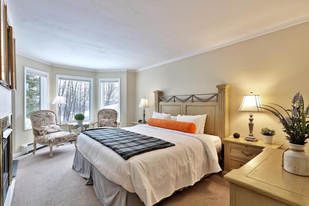 um quarto com uma cama grande e 2 cadeiras em The Birch Ridge- European Room #8 - King Suite in Killington, Vermont, Hot Tub, home em Killington