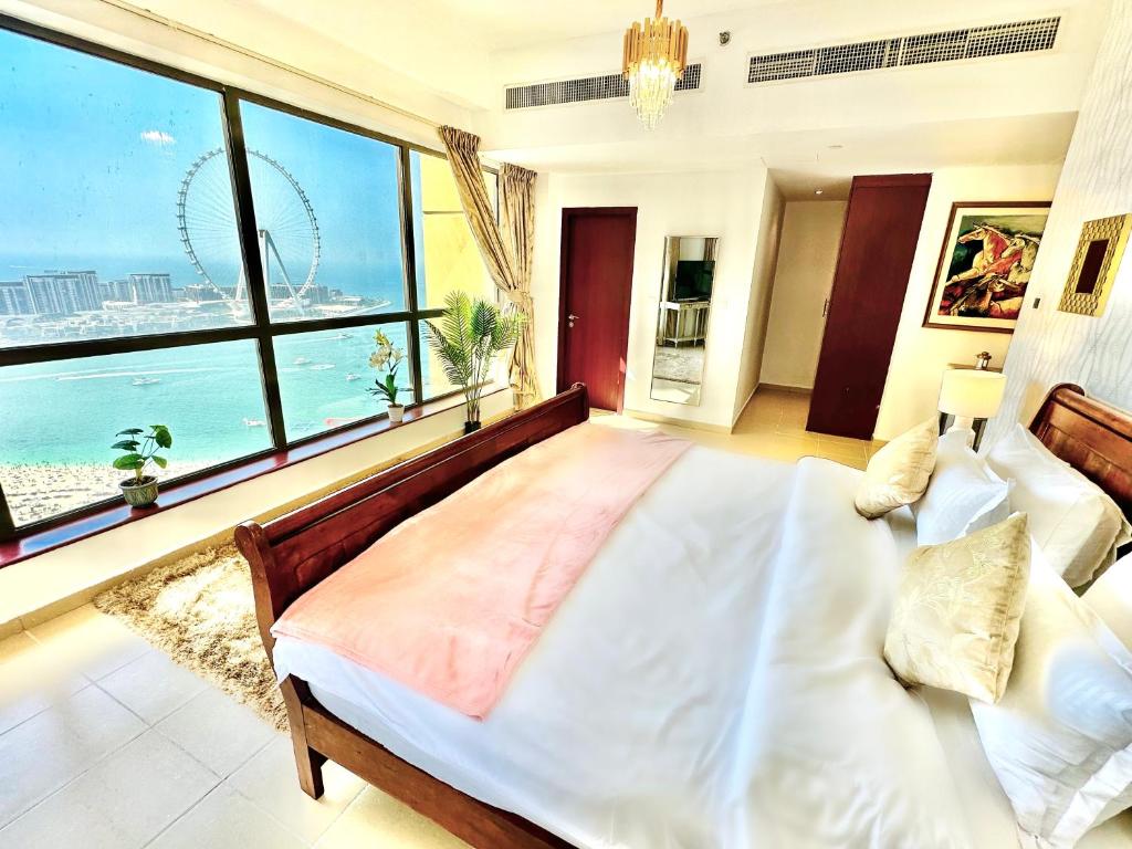ein Schlafzimmer mit einem großen Bett und einem großen Fenster in der Unterkunft Luxury Casa - Indigo Sea View Apartment JBR Beach 2BR in Dubai