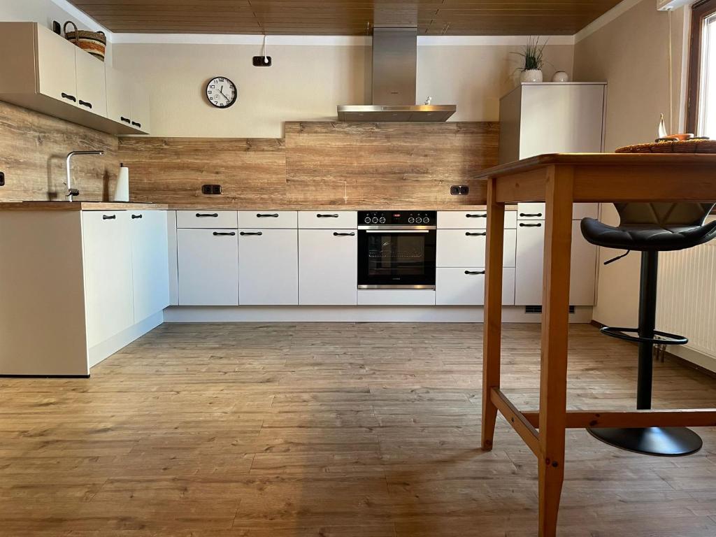 a kitchen with white cabinets and a wooden floor at Ferienhaus Janne in Monschau