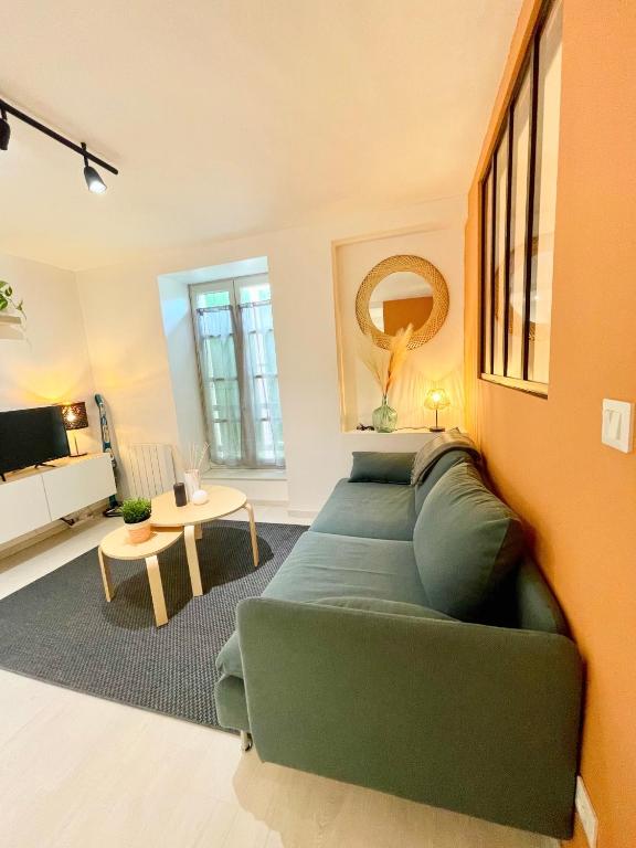 salon z zieloną kanapą i stołem w obiekcie Grand studio Hyper centre WIFI w mieście Rodez