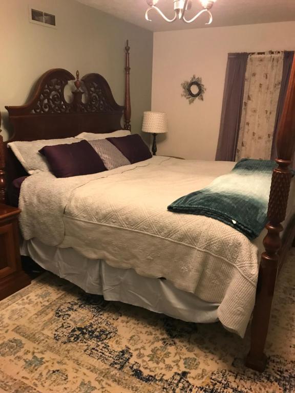 カントンにあるHope Bed and Breakfastのベッドルーム1室(大型ベッド1台、木製ヘッドボード付)