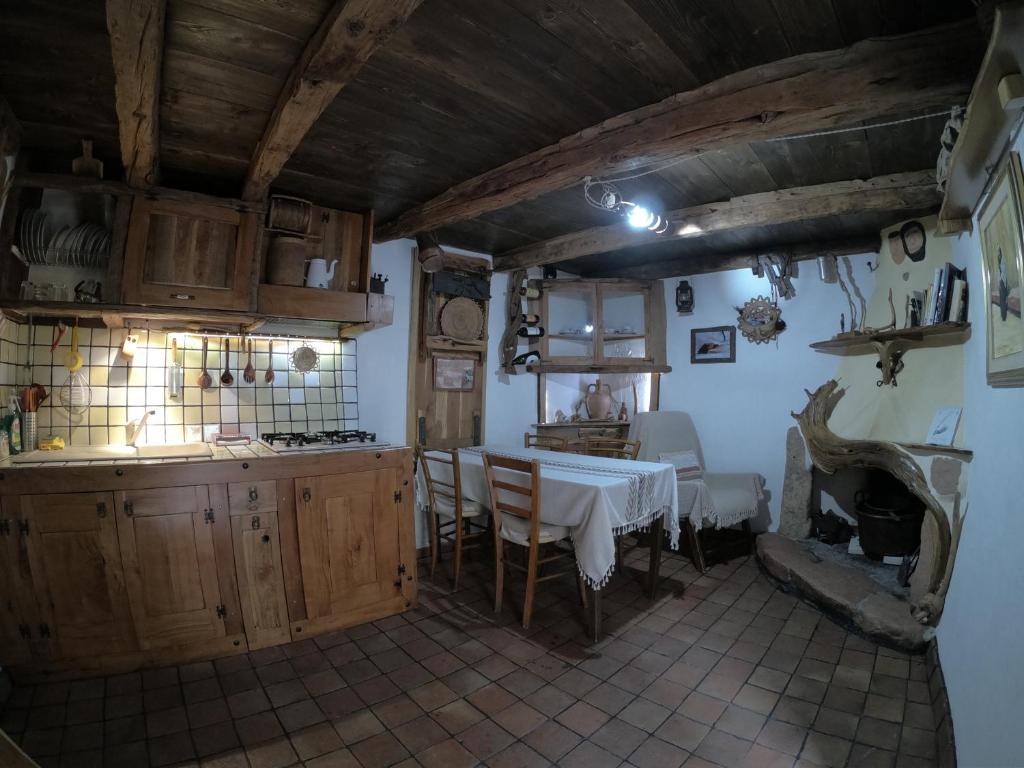 a kitchen with a table in the middle of a room at Sa domu 'eccia in Urzulei