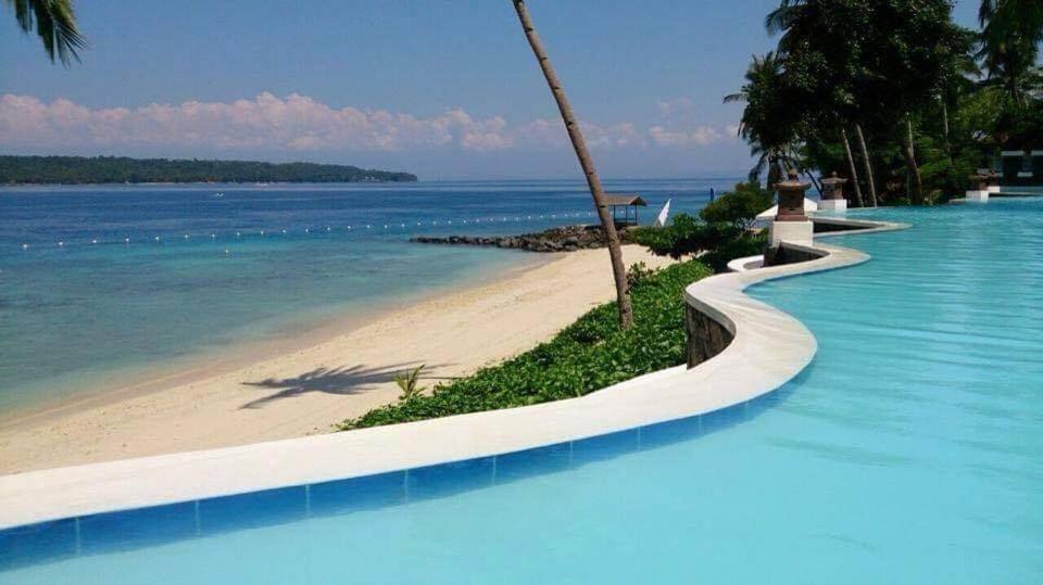 a swimming pool next to a beach next to the ocean at Kembali coast resort A-house style in Caliclic