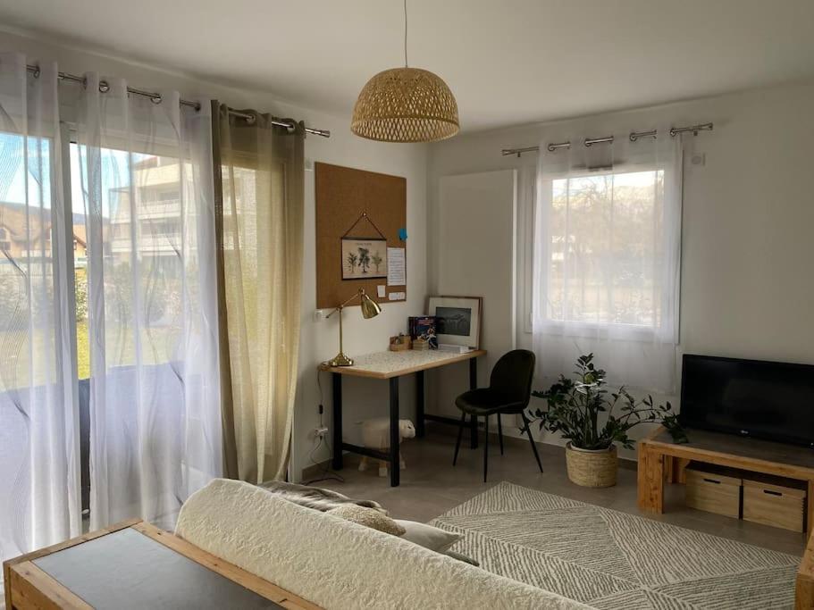 聖若里奧的住宿－Appartement neuf au calme proche du lac，客厅配有沙发、桌子和书桌