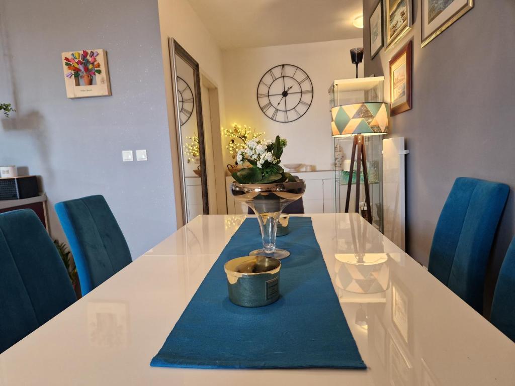 - une table à manger avec une serviette bleue et un vase dans l'établissement Apartment Pupila, à Solin