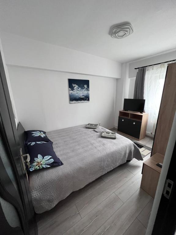 a bedroom with a bed and a dresser and a television at Victoria apartment Miercurea Ciuc in Miercurea-Ciuc
