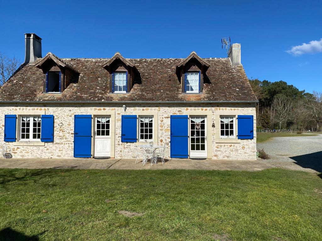 Una casa vieja con persianas azules. en Maison de Campagne Le Pâtis aux Chevaux proche circuit 24H et Le Mans, en Challes