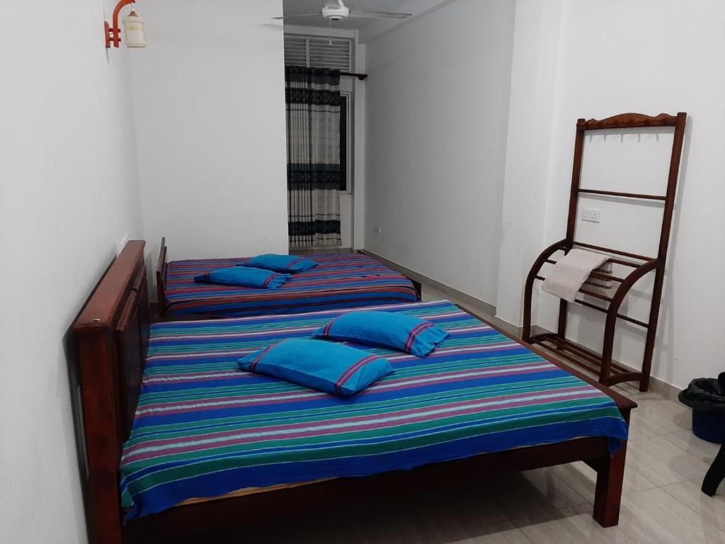 two beds in a room with blue pillows on them at Hotel Mount in Kurunegala