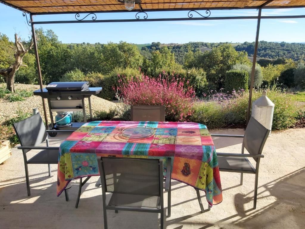 a table with chairs and a grill on a patio at Gites Lou Limbert in Valensole