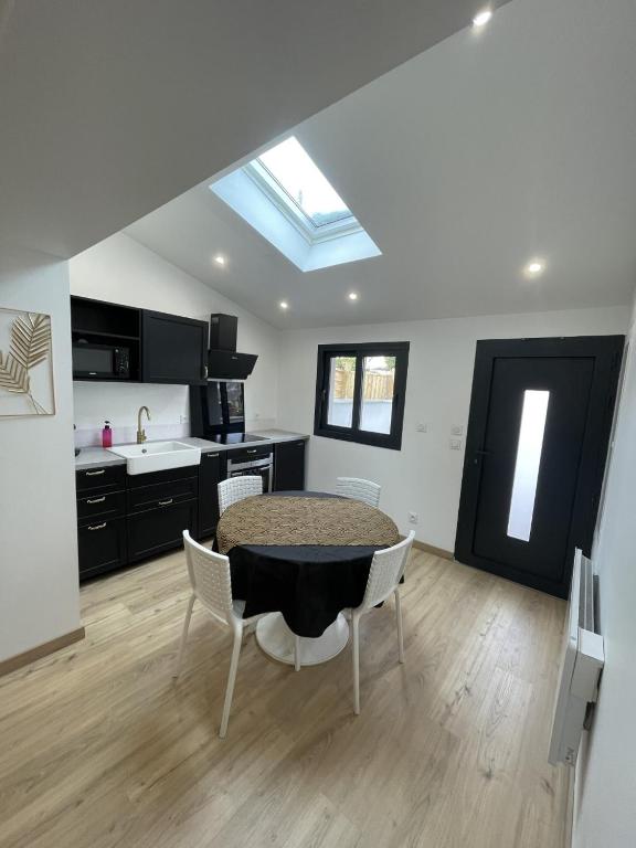 une cuisine avec une table et des chaises dans une pièce dans l'établissement Charmant T2, parking privé, à Argelès-Gazost