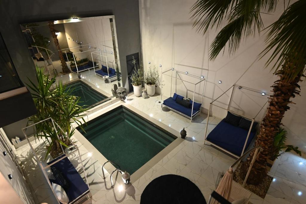 - une vue sur la piscine avec des chaises bleues dans l'établissement Riad 5 Chambres & Piscine & Breakfast - Marrakech, à Marrakech