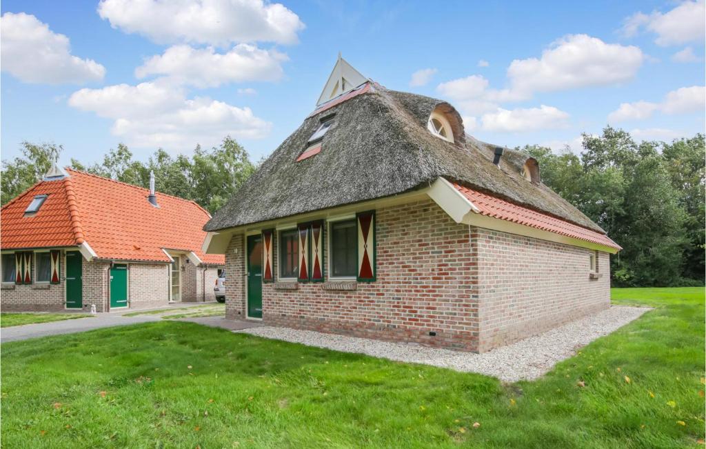 un antiguo edificio de ladrillo con techo de paja en un campo en 3 Bedroom Gorgeous Home In Ijhorst, en IJhorst