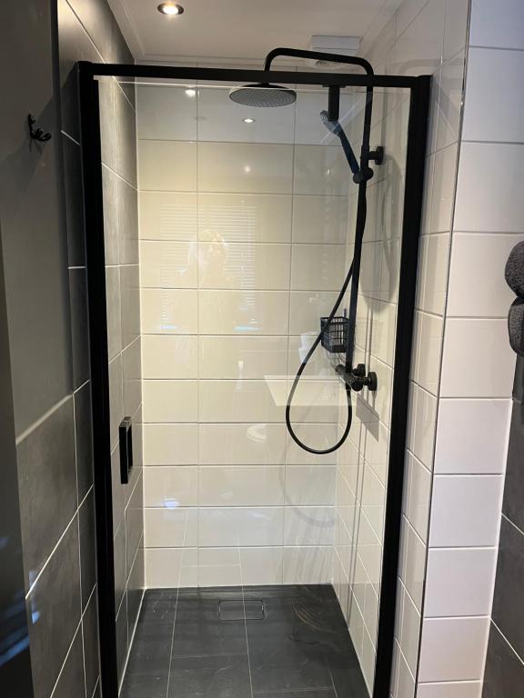 a shower with a glass door in a bathroom at B&B 'Op Eemdijk' in Eemdijk